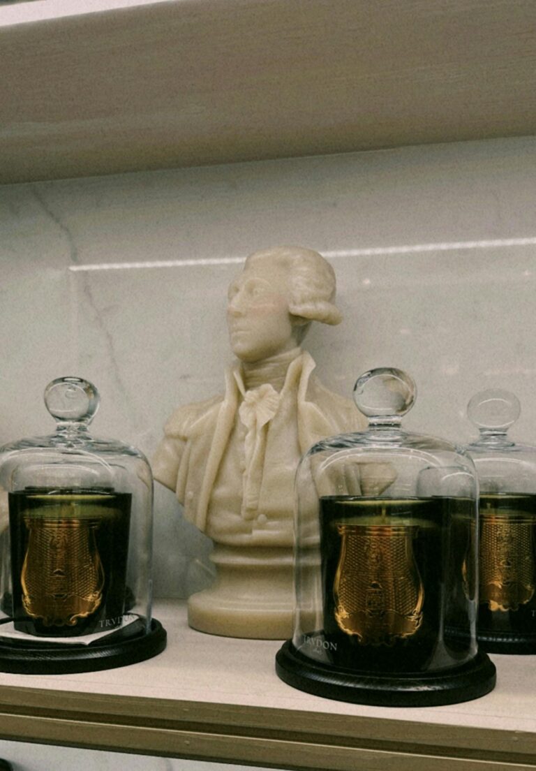 Luxurious candles with a marble statue on display in a Toronto store.