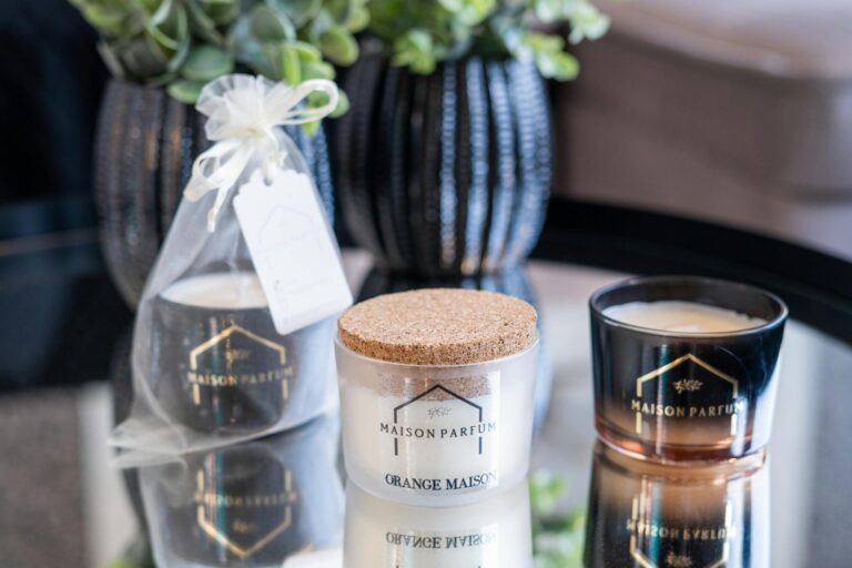 Luxurious scented candles from Maison Parfum on a reflective table enhancing home decor.